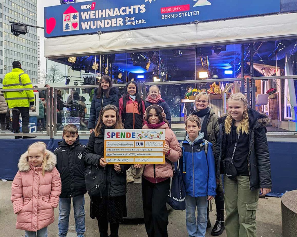 Foto mit Kindern des Garather Kinderparlaments während sie eine Spende an den WDR 2 übergeben